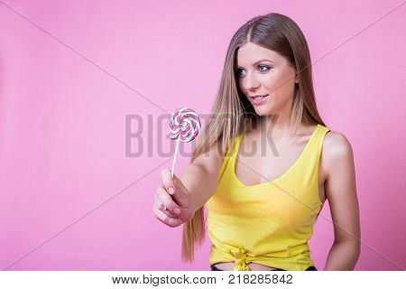 bright beautiful girl model with sweet candy on bright holiday background