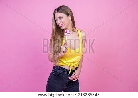 bright beautiful girl model with sweet candy on bright holiday background