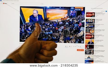 PARIS FRANCE - DEC 14 2017: Man thumb up for the Russian President - watching on Youtube live channel of Rossiya RTR the Russian President Vladimir Putin give final media Q&A before March election