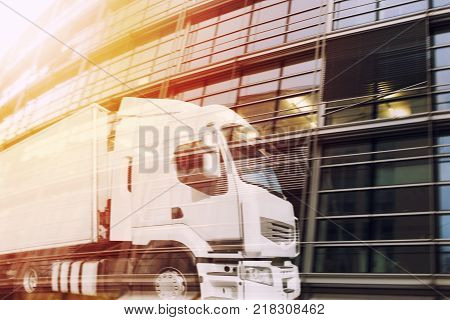 Fast white truck reflected on a skyscraper. double exposure