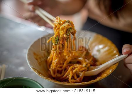 Fried Hokkien Noodles tong by chopsticks ready to eat in the southern of Thailand Phuket local Food