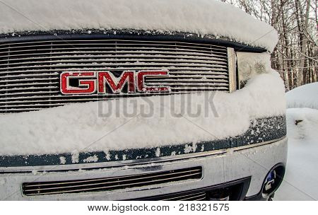 Port Huron, Michigan, USA - December 14, 2017: Front bumper and grill of a GMC truck covered in snow and ice after a snow storm slams the Midwest.