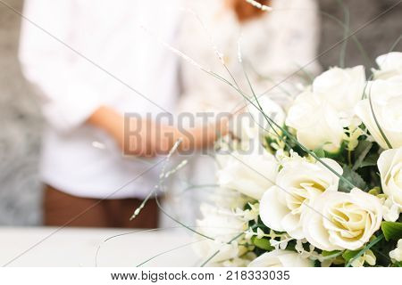 close up white flower and couple hold hands on blur background love concept