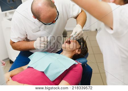 Close Up Process Of Preparing And Installing Dental Ceramic Crown. Male Professional Dentist Helps T