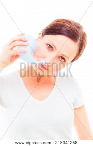 Studio shot of an adult woman using neti pot