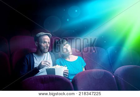 Teenager couple cuddling and watching the climax part of the movie