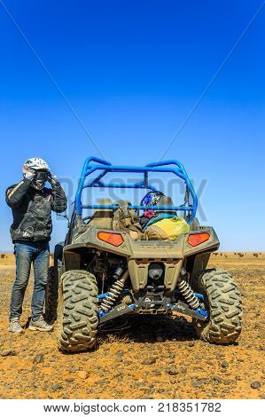 Ait Saoun Morocco - February 23 2016: Man preparing to ride a quad bike along the sandy desert Ait Saoun in Morocco.