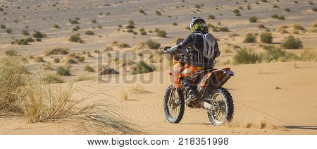 Ait Saoun Morocco - February 25 2016: back vue of man in helmet riding bike in Ait Saoun desert of Morocco