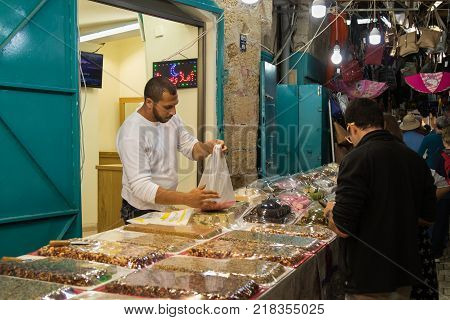 Acre Israel November 03 2017 : The seller sells sweets to the customer on the market in the old town of Acre in Israel