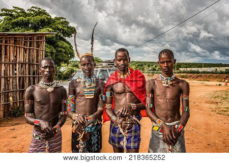TURMI, OMO VALLEY, ETHIOPIA - MAY 5, 2015: Young men from the ethiopian tribes tsamai, Banna and Hamar with traditional jewelry at a popular local market.