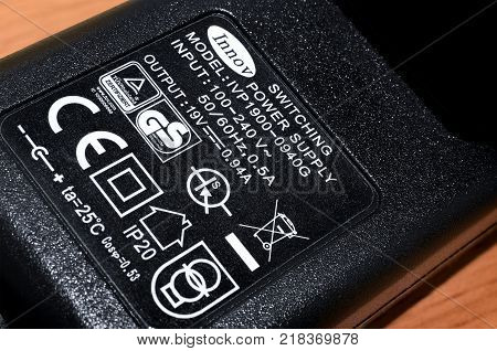 BANGKOK THAILAND - DECEMBER 15: Power specifications and various certification labels on a small AC to DC power adapter.