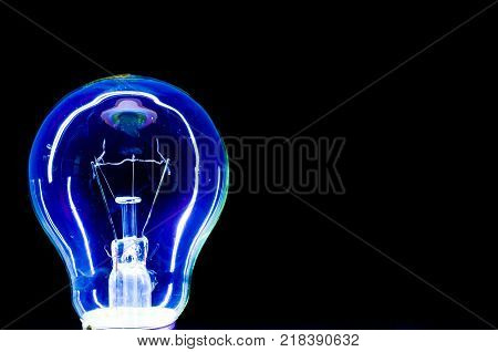 Blue light bulb isolated on black background