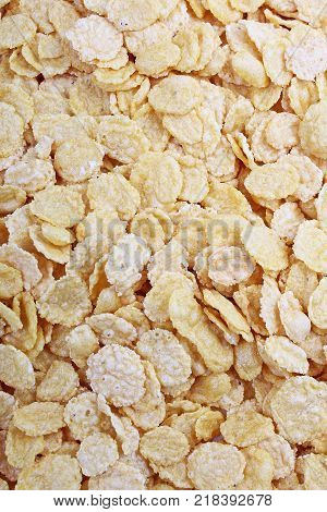 Corn flakes texture closeup pattern as background. Breakfast food photo. Cereals.