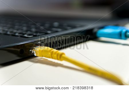 Various cables connected to the laptop on white background