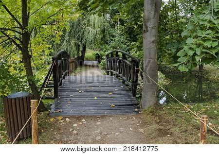 Forest, path and bridge in National monument of landscape architecture Park museum Vrana in former time royal palace on the outskirts of Sofia, Bulgaria, Europe