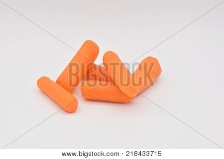 Peeled orange baby carrots arranged on a seamless white background.