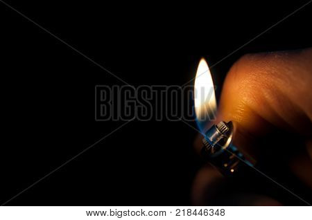 Man hand holding the cigarette lighter on black background.