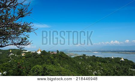 High angle view of multiple temples and pagodas on the mountains with Irrawaddy river in the background from sagaing hill, Sagaing region of Myanmar.