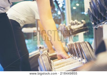 Fitness Woman Lifting Weight for Exercise in Gym Selective focus on Weight Handle