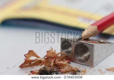 Sharpener, sharpened pencil, crossword in the background.