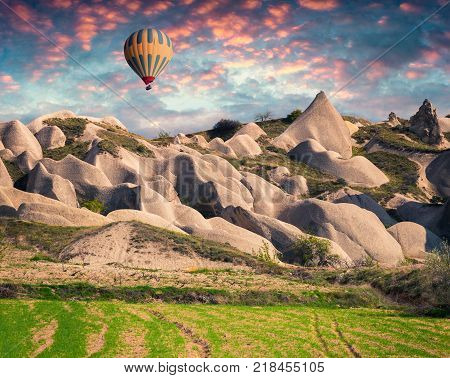 Unreal world of Cappadocia. Sunrise in Red Rose valley in April. Cavusin village located district of Avanos in Nevsehir Province in the Cappadocia region of Turkey Asia.