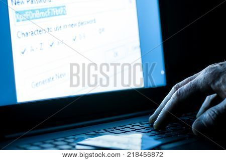 Stolen credit card, hacker in the fron of laptop working on the password.