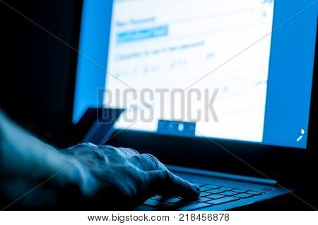 Stolen credit card, hacker in the fron of laptop working on the password.