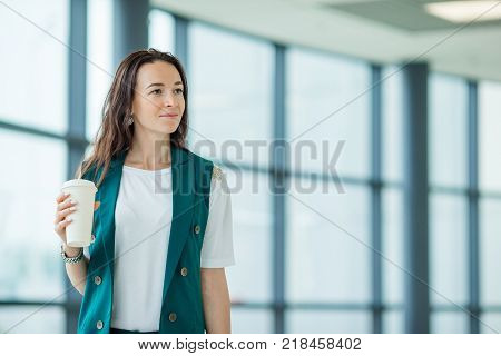 Young woman in international airport walking with her luggage.