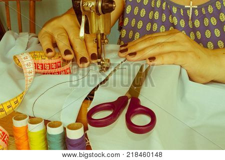 closeup of woman hands sewing yellow cloth outdoors. Woman's Hand Sewing Quilt