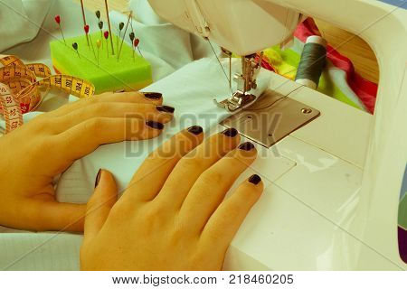 processes of sewing on the sewing machine sew women's hands sewing machine. Female tailor threading leather material on sewing machine