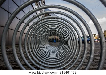 a bicycle stand and a wheelchair space that looks futuristic and interesting. geometric vision and perceptual composition. lines and a tunnel of steel and iron spirals.