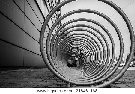 a bicycle stand and a wheelchair space that looks futuristic and interesting. geometric vision and perceptual composition. lines and a tunnel of steel and iron spirals.