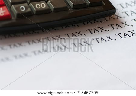 Old, used office calculator, increasing tax text on white paper, tax increasing conceptual image.