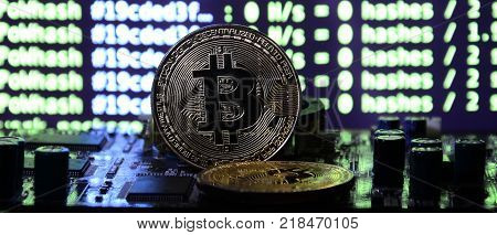 The digital process of cryptocurrency mining by using the GPUs. Bitcoins and video card on a working display and mining screen