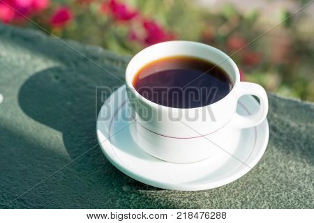 Morning cup of tea drinking on balcony on flower background