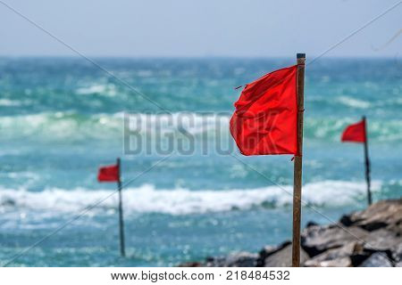 Red warning flag on beach showing that swimming is dangerous or prohibited