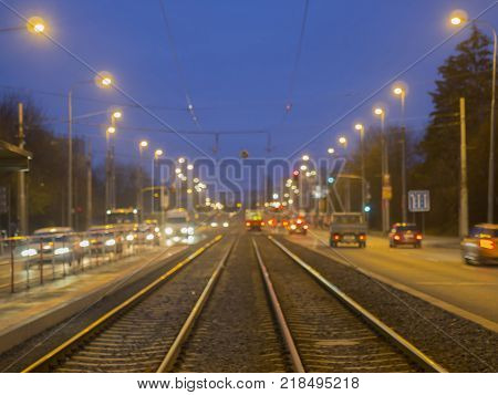 colorful blurred street tramway line with traffic lights with defocused tram and cars during twiling