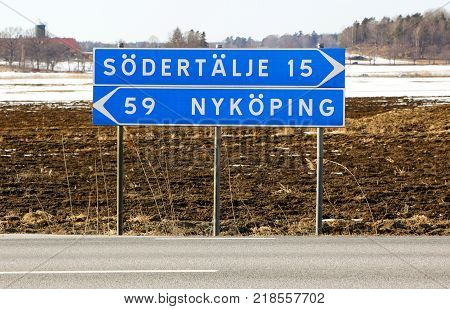Signpost at the intersection with the distance in kilometers to Sodertalje and Nykoping.