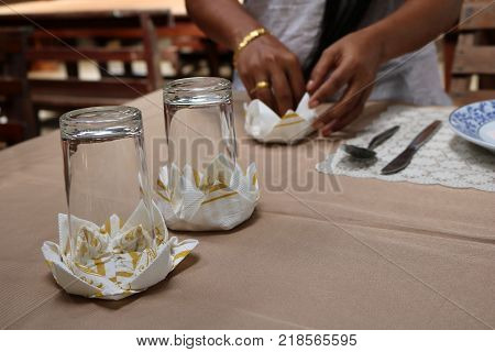 Asian women practice folding the fabric nepkin in Thailand.