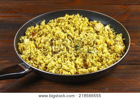 Indian biryani with chicken, yogurt and spices in a plate on a wooden table. New Year's, Christmas dish