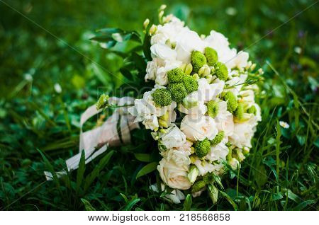 Whiteand Green Wedding Bouquet Lying On The Grass