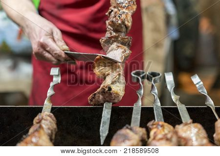 The cook cuts meat on a shapur