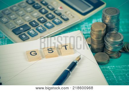 Word Of Gst On Wooden Alphabet Blocks On Calculator .selective Focus,shallow Depth Of Field. Finance