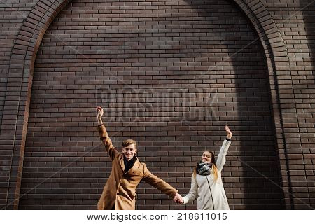 Couple in love have fun outdoor. Hands in the air. Young carefree romantic relationship. Free space concept