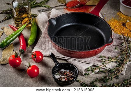 Grey stone culinary background with empty black pan and selection of spices and seasonings top view copy space