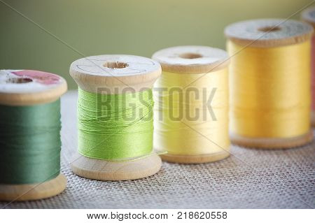 Antique Wooden Spools of Yellow and Green Sewing Thread