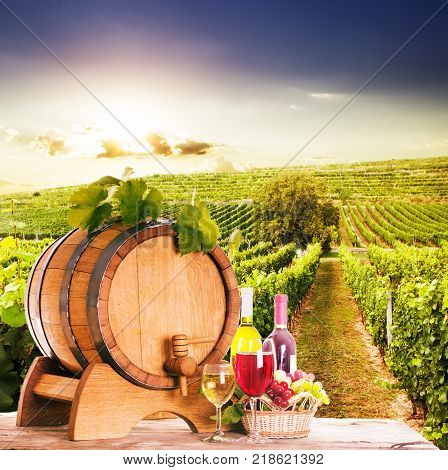 Grapes and bottels of wine near the wooden barrel. Glasses of wine on the table, concept of winery - red and white