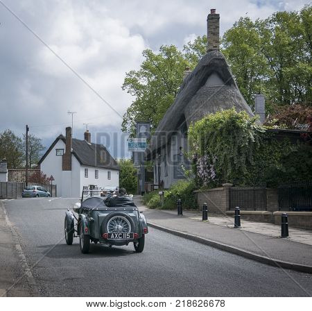 FOWLMERE, CAMBRIDGESHIRE, UK, MAY 2017 - View of a vintage Wolesley Hornet car driving through the pretty village of Fowlmere Cambridgeshire England UK