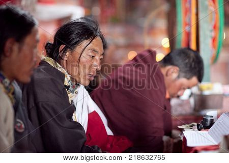 NGARI, TIBET, CHINA - APRIL 28, 2013: Buddhist monks praying during Puja ceremony in Chiu Gompa, Western Tibet