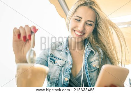 Young woman using smartphone at coffee bar - Fashion blogger girl sharing content with mobile smart phone drinking latte - Modern tourist wander lifestyle concept on social media network communication